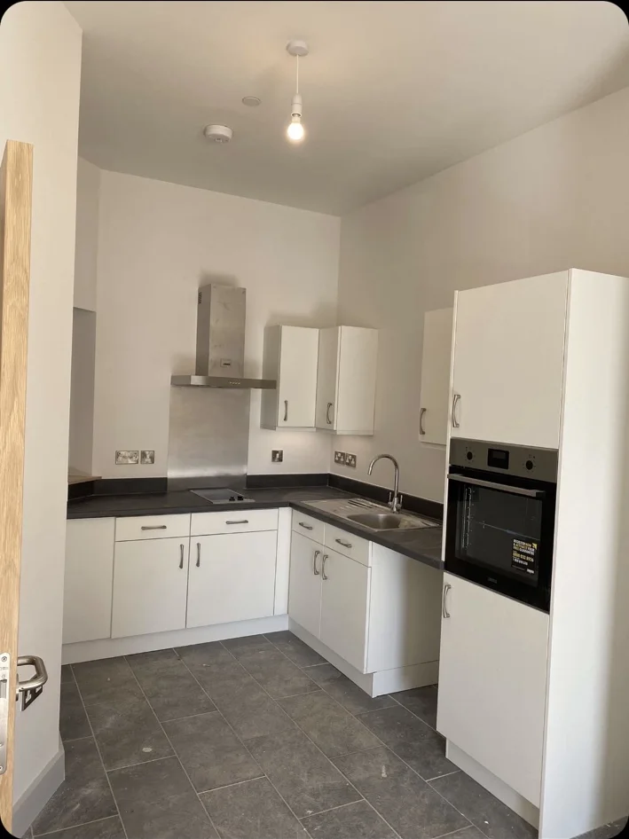 White fitted kitchen with black worktop
