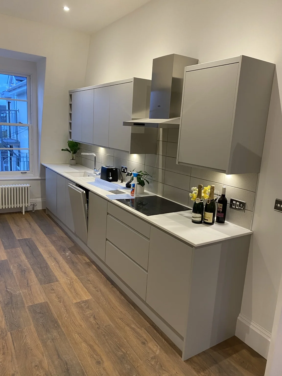 Fitted grey kitchen with worktop and wall cabinets