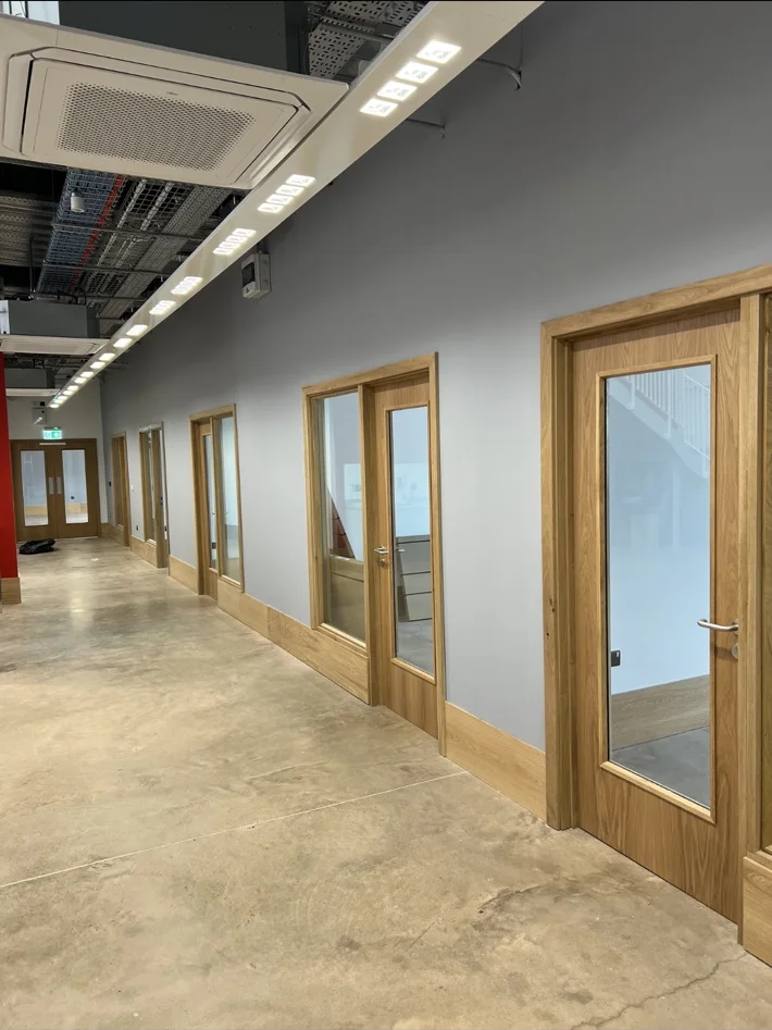 Timber doors and glazed screens along a commercial corridor